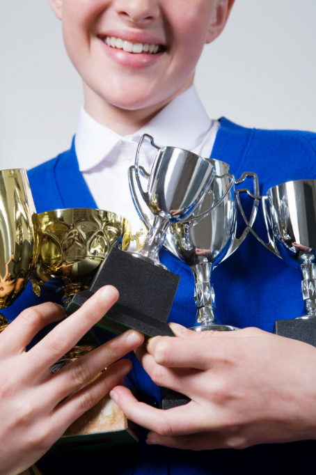 Perfectionist girl holds several trophies