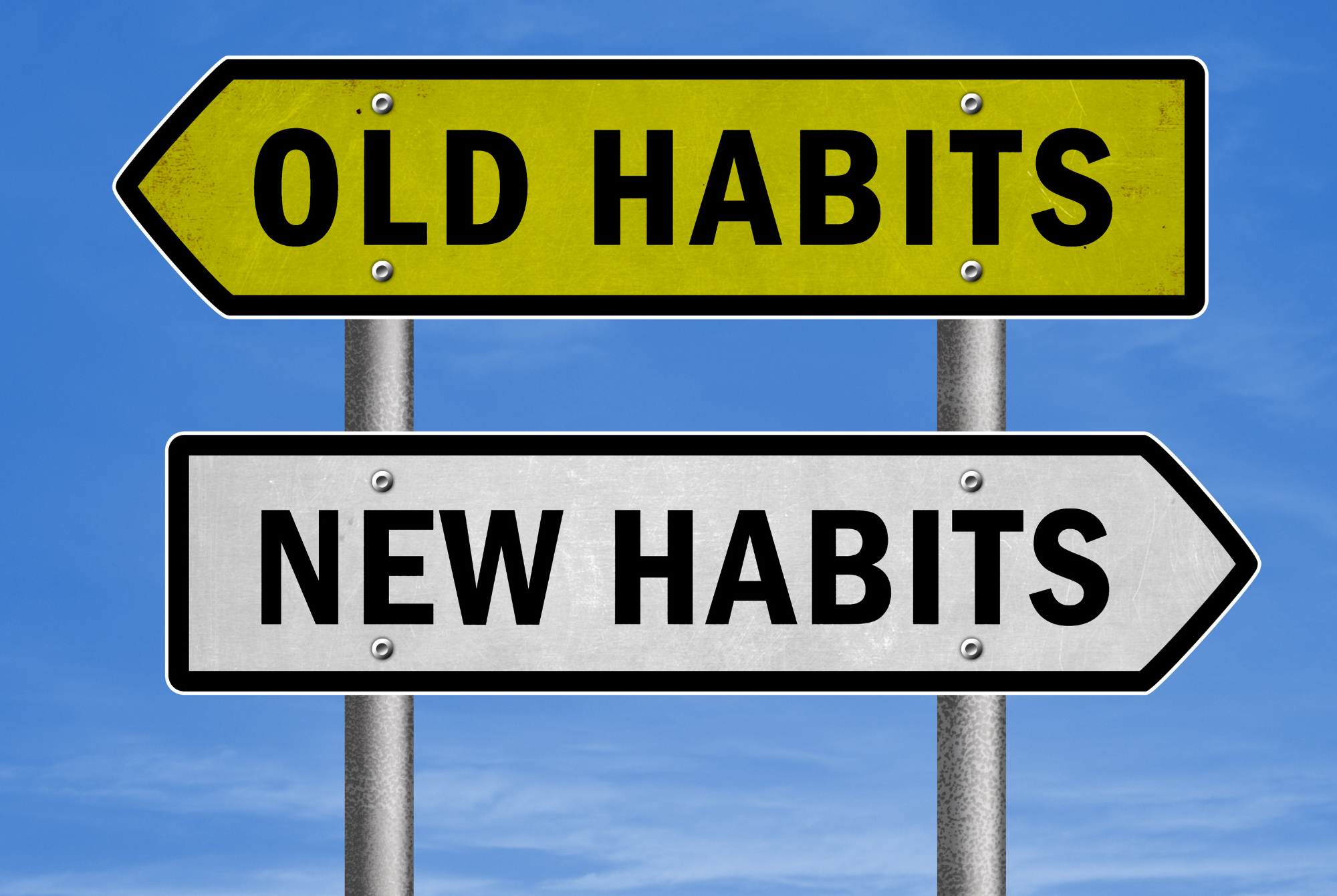 Two road signs point in opposite directions; one to "Old Habits" and the other to "New Habits."