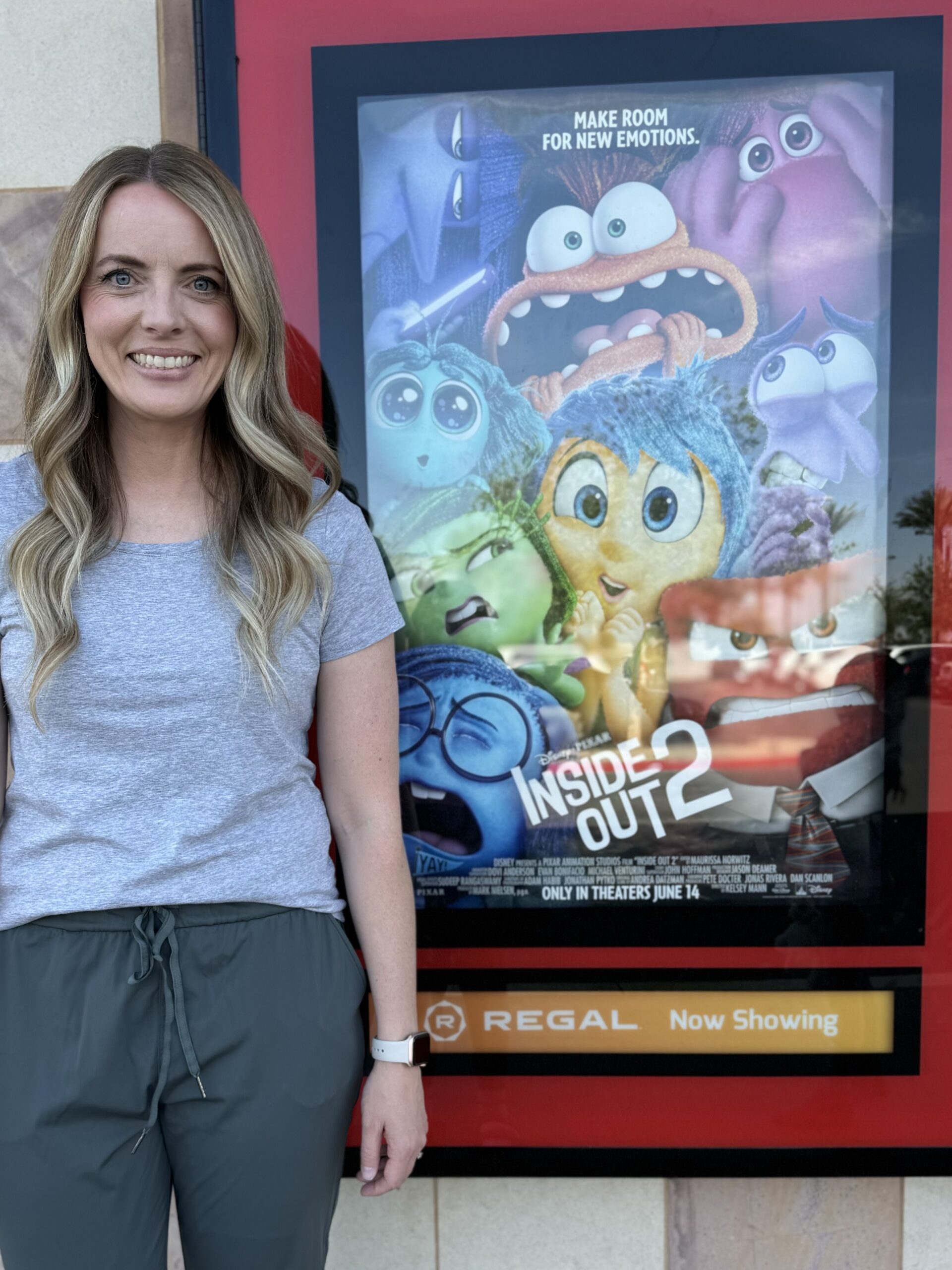 Stephanie Valdez stands in front of the Inside Out 2 movie poster
