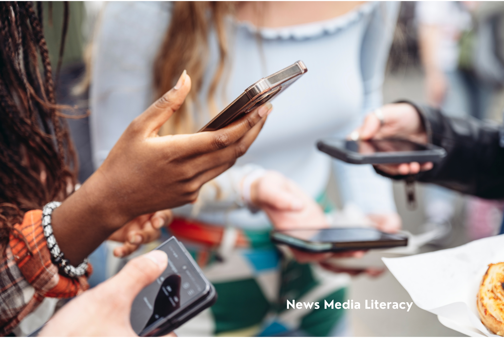 Tween or teen girls are grouped together holding their smartphones and practicing news media literacy.