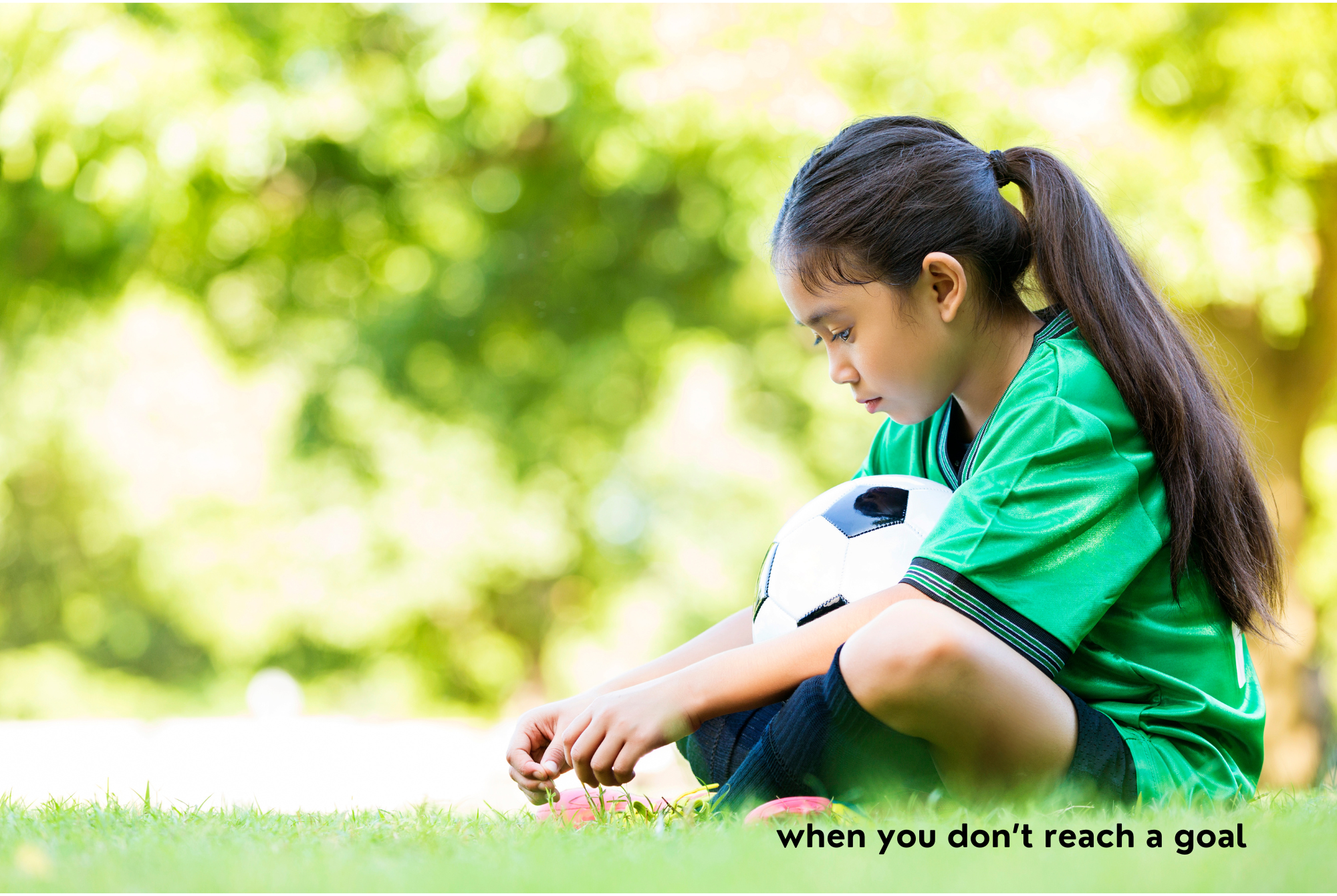 A tween or tween girl wearing a soccer uniform sits on the grass with a sad expression because she did not reach her goal