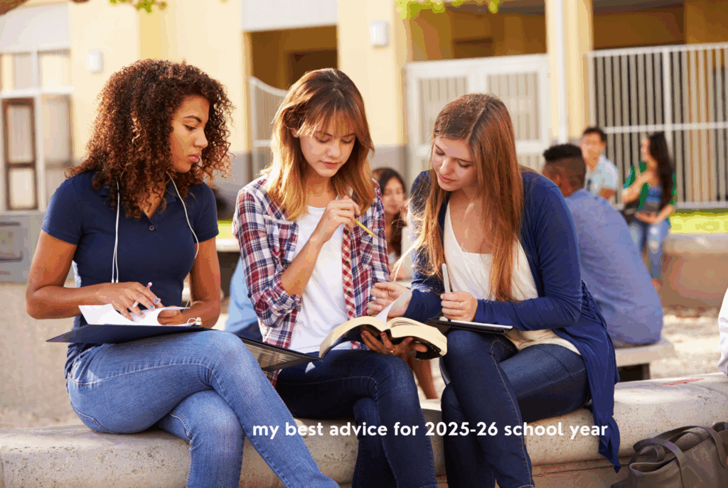 Three tween or teen girls sit in a school courtyard working together on homework.