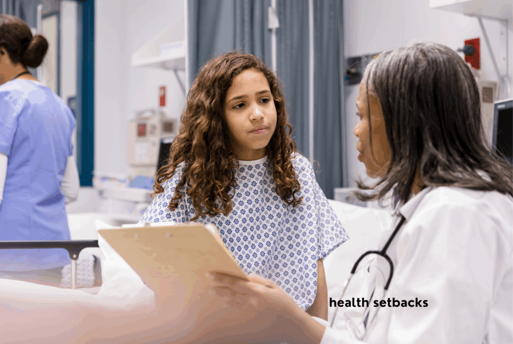 A teen or tween girl with tan skin and long brown curly hair sits on a hospital bed talking to a doctor with dark skin and black hair about her health setback.